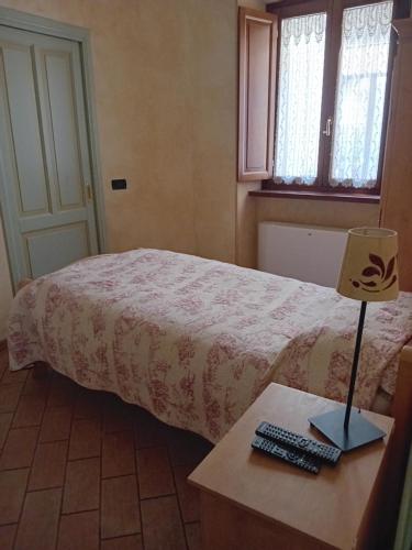 a bedroom with a bed and a table with a lamp at La Casa dei Nonni in Berceto