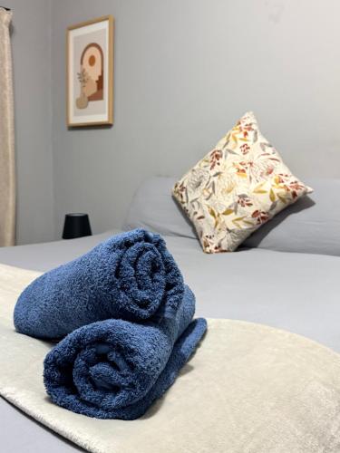 a blue towel sitting on top of a bed at Ekukhanyeni Guest house in Kwaluseni