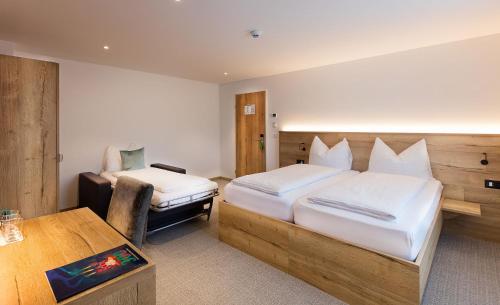 a bedroom with two beds and a desk and a table at Hotel Vaduzerhof by b-smart in Vaduz