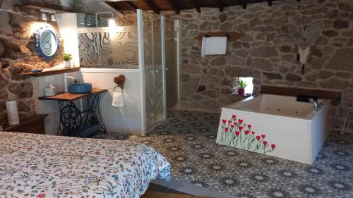 a bedroom with a bed and a bath tub at Casiñas De Acevedo in Junquera de Ambía