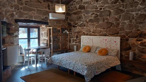 a bedroom with a bed and a stone wall at Casiñas De Acevedo in Junquera de Ambía