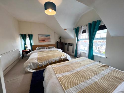 a attic bedroom with two beds and a window at Chip's House in Pennyburn