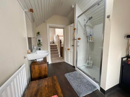 a bathroom with a shower and a sink at Chip's House in Pennyburn
