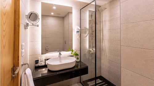 a bathroom with a sink and a shower at Obelisk Nile Towers in Aswan