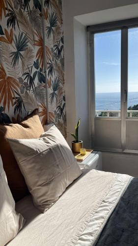 a bedroom with a bed and a window with a view at Holibai Mirada do Roxo 3 suites y vistas al mar in Oia
