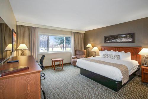 a hotel room with a bed and a desk at C'mon Inn Missoula in Missoula
