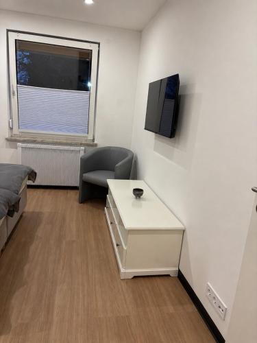 ein Zimmer mit einem Bett, einem Tisch und einem Fernseher in der Unterkunft WeserZeit Apartment in Bodenwerder