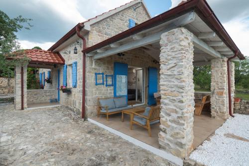 a stone house with a porch with a stone wall at House Toma in Oklaj