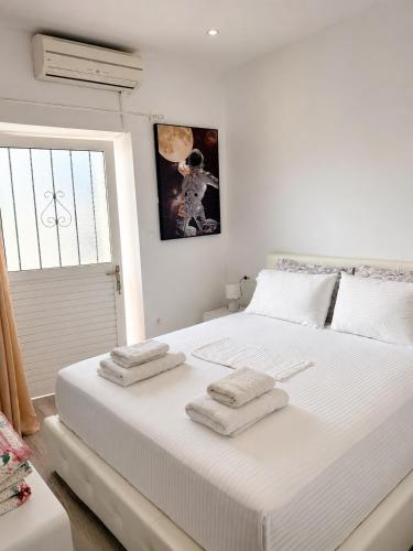 a bedroom with a large white bed with towels on it at G&D guest house in Ancient Epidauros