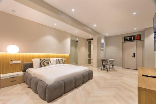 a bedroom with a large bed and a table at The District Lekki by GCI in Lekki Phase 1