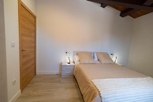 a bedroom with a large bed and a wooden door at Casa ATARAXIA in Boiro
