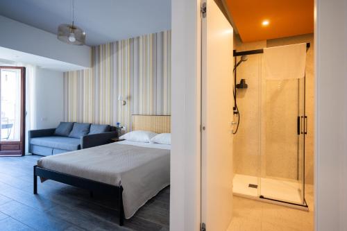 a bedroom with a bed and a bathroom with a shower at Garibaldi Suite B&B in Salerno