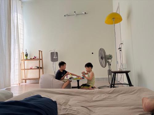 two children playing with a table in a bedroom at Anhbnb in Danang