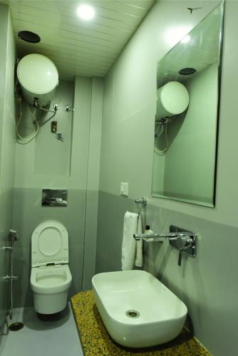 a bathroom with a toilet and a sink and a mirror at The Marwar regency Hotel in Jodhpur