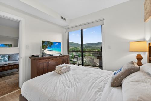 a bedroom with a white bed and a large window at Playa Del Sol 2 Bdrm 649 w/ Mountain Views! in Kelowna