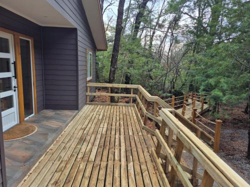 a wooden porch of a house with a fence at Complejo Alto La Invernada in Las Trancas