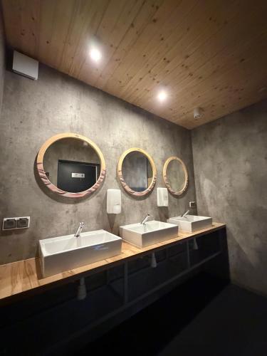a bathroom with two sinks and two mirrors at Highway to Hel in Jastarnia
