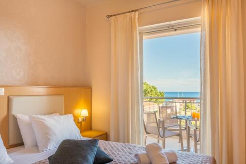 a bedroom with a bed and a view of the ocean at Vereniki Apartments in Finikounta