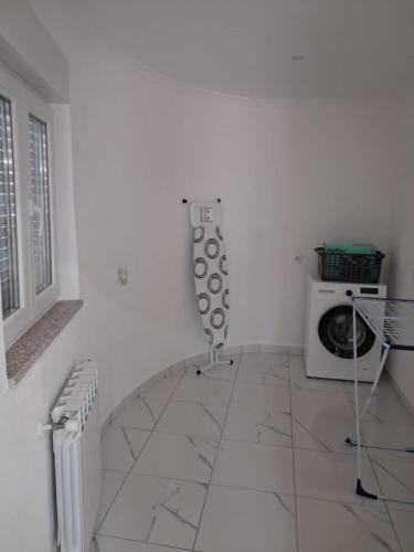 a white room with a microwave and a table at Casa D'Avó 1 in Trancoso