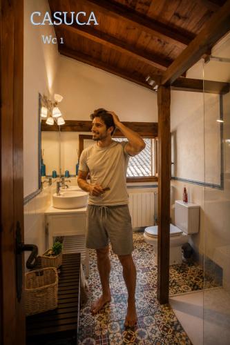 a man standing in a bathroom with a mirror at Casa rural Paraje de Yuste in Cuacos de Yuste