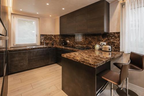 a kitchen with black cabinets and a granite counter top at Maison Villa Scherlin in Bardolino