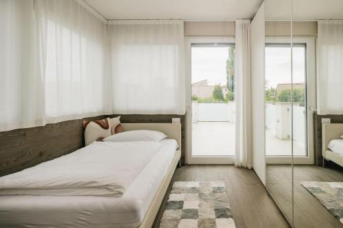 a bedroom with a bed and a large window at Maison Villa Scherlin in Bardolino