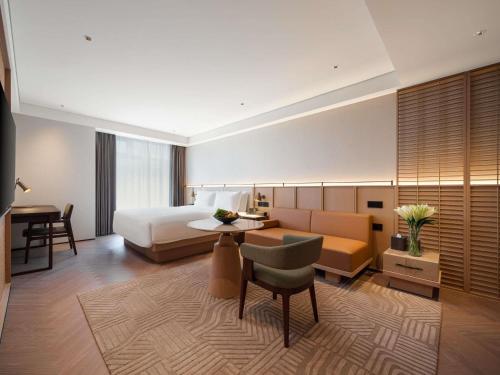 a hotel room with a bed and a desk at Ming Hotel Nanjing - MGallery Collection in Nanjing