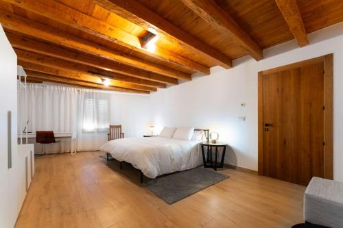 a bedroom with a bed and a wooden ceiling at Hotel Rural Alecook in Valcabado