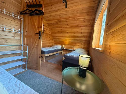 a room with a bed and a table in a cabin at #Fuleda#Giżycko Fuledzianka domek na Mazurach #bania #jacuzziklimat in Giżycko