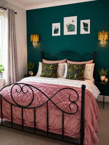 a bedroom with a bed with a pink comforter at Afan Forest Retreat Bikes, Pets, Family,Workers in Cymmer