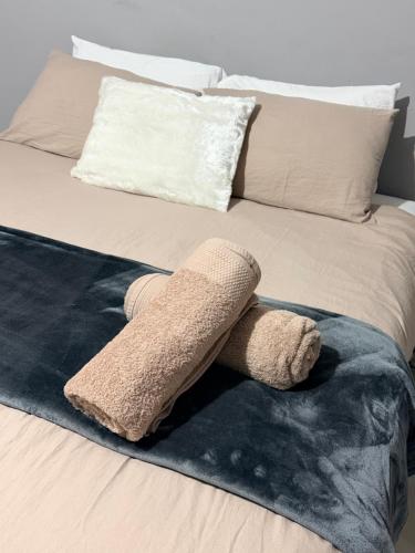 a towel on a bed with a sock on it at Ekukhanyeni Guest house in Kwaluseni