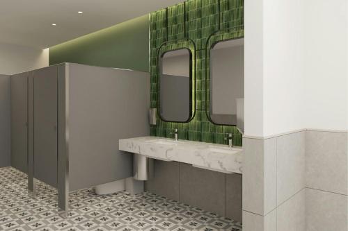 a bathroom with two sinks and two mirrors at Courtyard by Marriott Torreón in Torreón