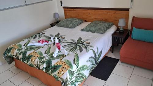a bedroom with a bed with a pineapple bedspread at Studio du PARADIS et Maison Vue sur Mer à 10 minutes des belles plages in Le Marin