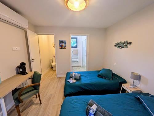 a room with two beds and a desk and a desk at Les Pignottes in Gujan-Mestras