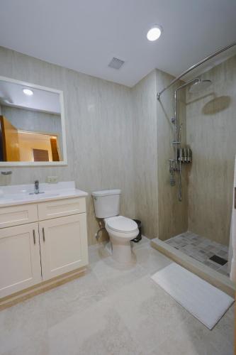 a bathroom with a toilet and a shower and a sink at Santa Cruz Suites in Lower South Hill