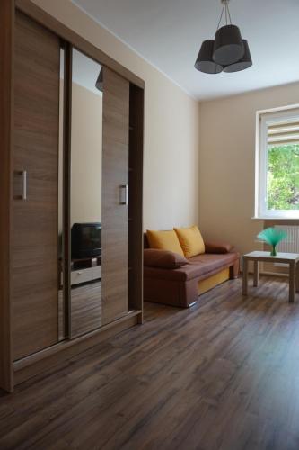 a living room with a couch and a sliding door at Baltic Rooms Gdańsk in Skorka