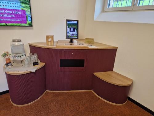 a counter with two stools and a computer on a wall at Kloster by b-smart in Schaan