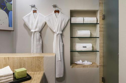 a bathroom with three white shirts hanging on a wall at The Westin Cancun Resort & Spa in Cancún