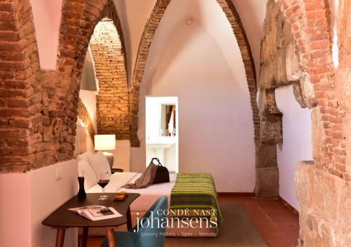 a bedroom with a bed and a table in a room at Noble House Essence Évora - by Unlock Hotels in Évora