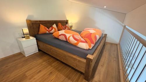 a bedroom with a wooden bed with pillows on it at Davenna Loft in Bartholomäberg