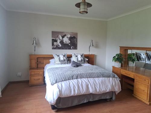 a bedroom with a bed and a wooden dresser at Barnfires Farmhouse in Denysville