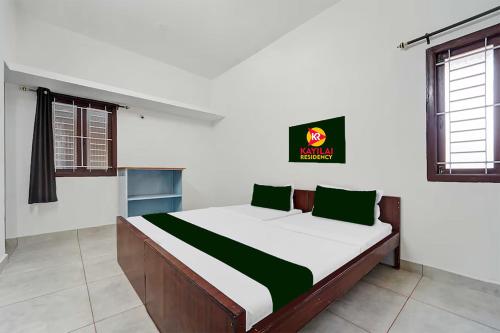 a bedroom with a large bed in a room at Kayilai Residency in Pīlamedu