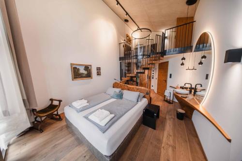a bedroom with a large bed and a staircase at Boutique-Hotel LARTOR in Unterammergau