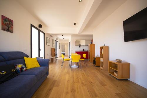 a living room with a blue couch and yellow chairs at Solemar Sicilia - Torre Maqueda in Palermo