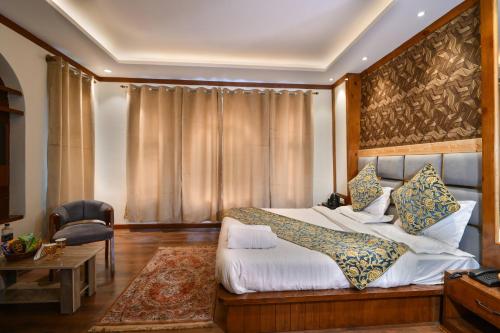 a bedroom with a large bed and a chair at The Forest Castle Resort in Pahalgām