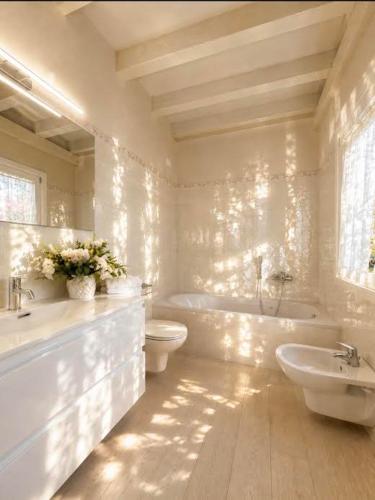 a bathroom with two sinks and a tub and a toilet at Lake View 49 in Sale Marasino