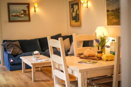 a table and chairs in a living room with a couch at Heathend in Petworth