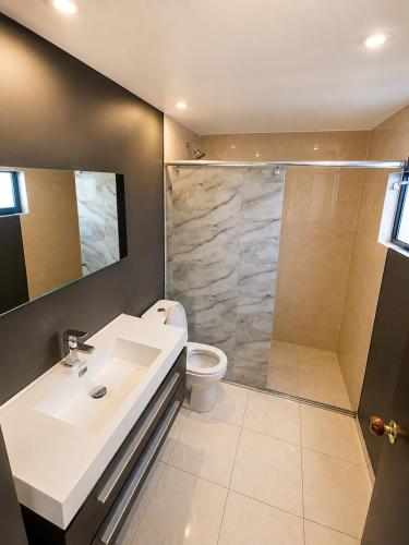 a bathroom with a toilet and a sink and a shower at Casa Corferias in Bogotá