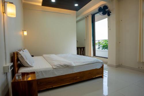 a bedroom with a bed and a large window at Seven Miles Hotel in Āīzawl
