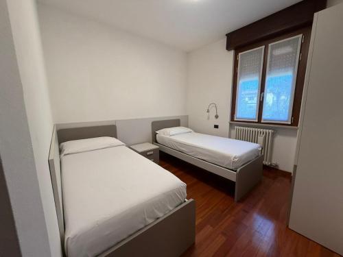 a room with two beds and a window at Appartamenti HERA in Lazise